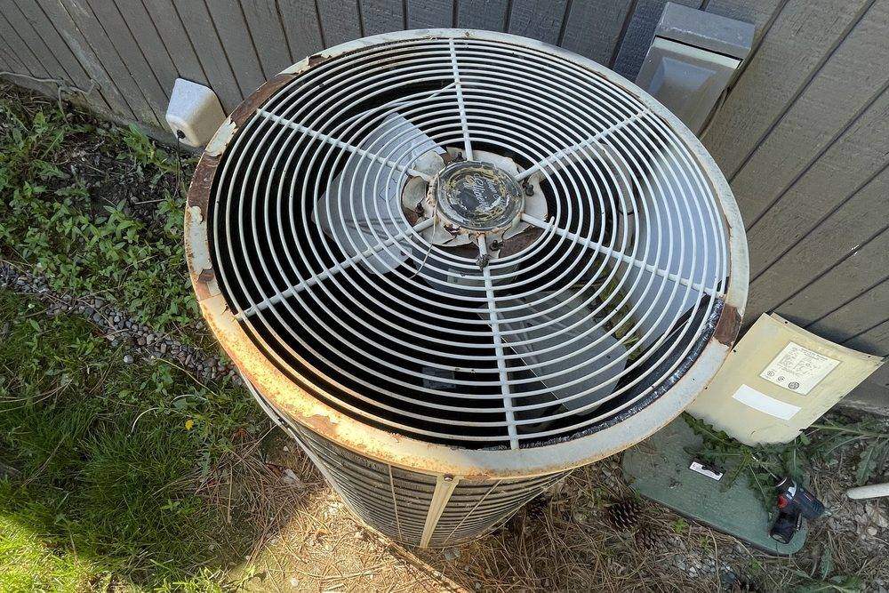 Old rusted round condensing unit seen from above