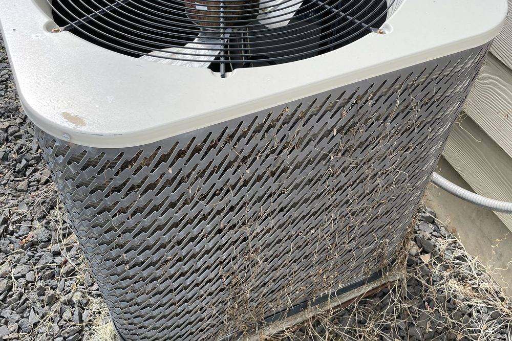Outdoor condensing unit with grass grown up around it