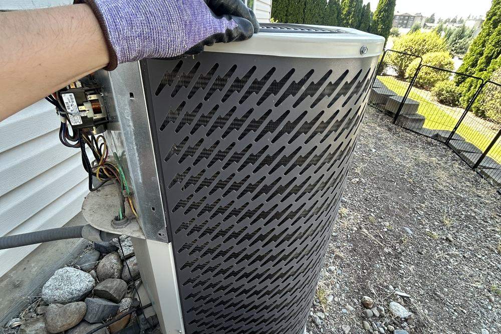 Technician opening the electrical panel on an outdoor unit