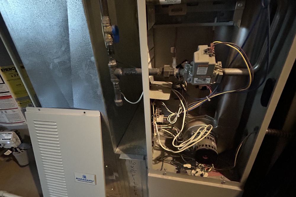 Furnace cabinet open next to an air handler and gas piping